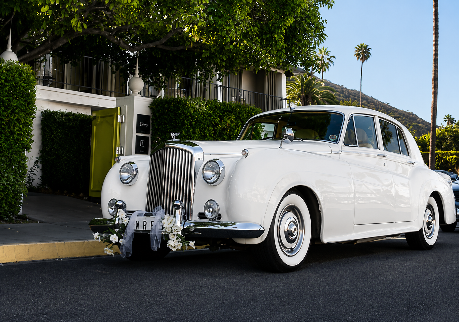 Vintage Bentley wedding transportation with fresh floral swag on the front grille in Laguna Beach