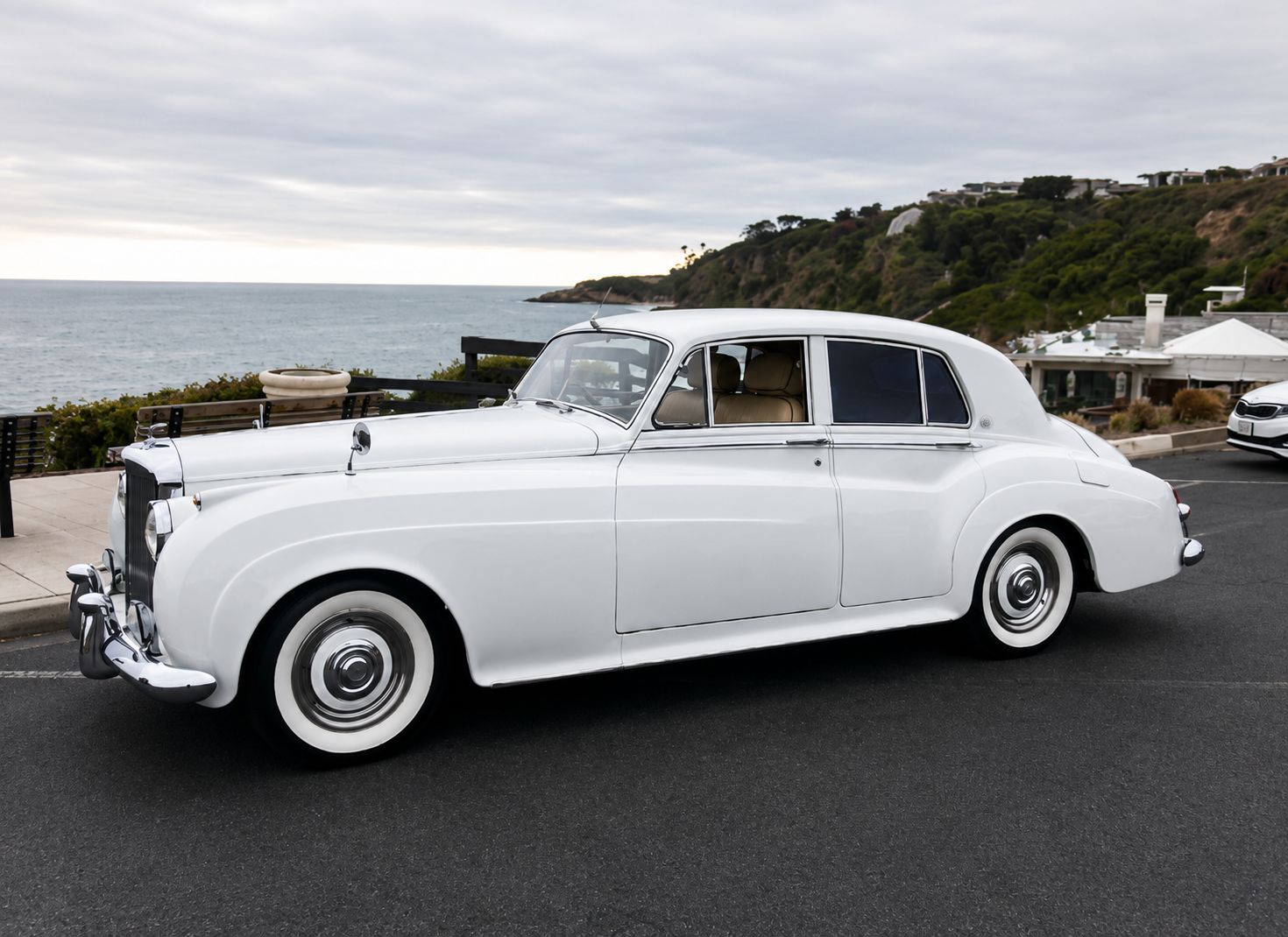 Luxury wedding getaway car — 1956 white Bentley parked at a coastal overlook in Dana Point