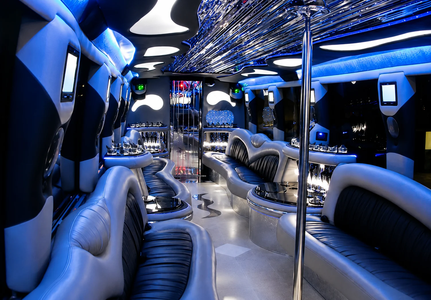 Luxury coach party bus interior with blue LED lighting, dance pole and full bar