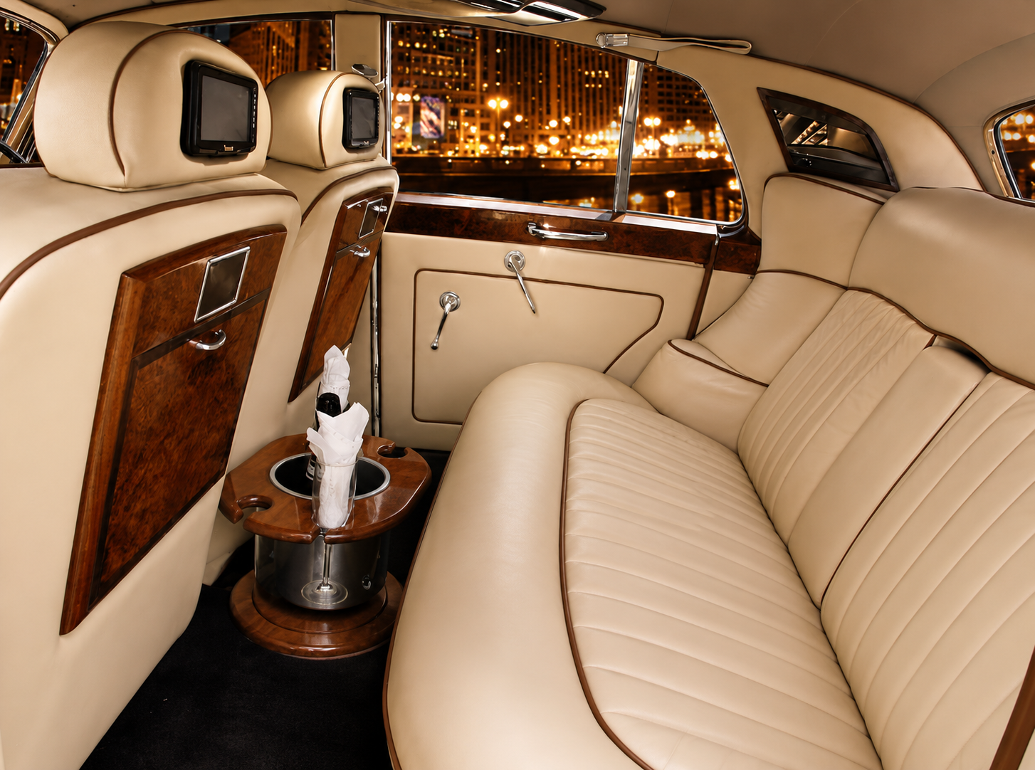 Bentley wedding chauffeur interior with Palomino leather and champagne bucket at night
