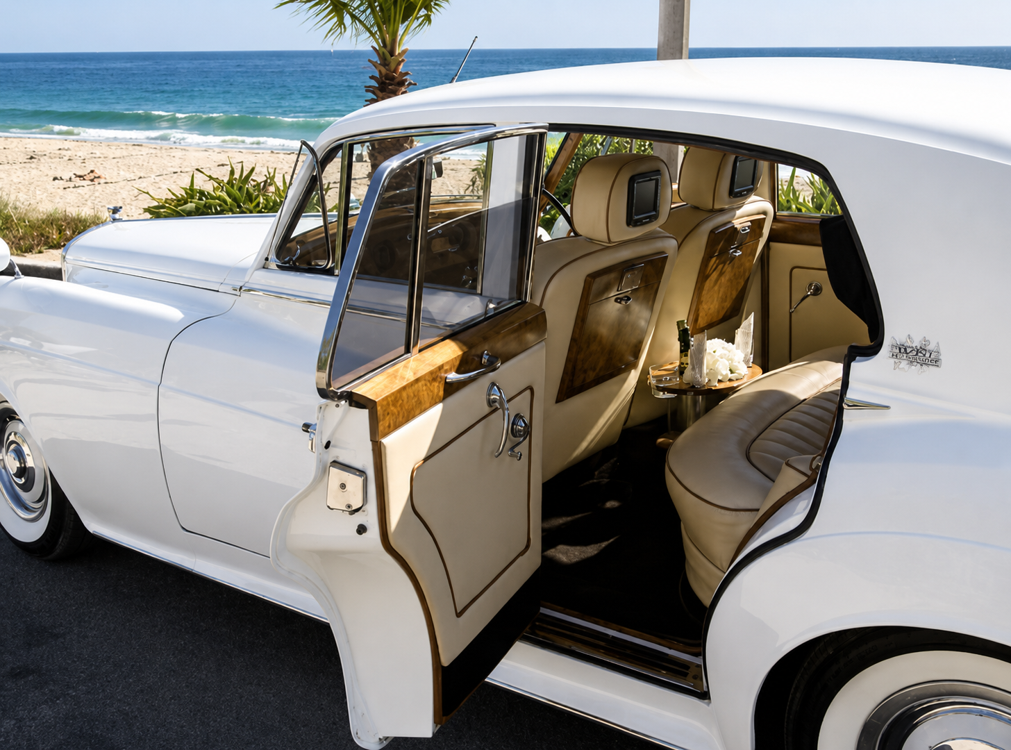 Classic Bentley bride and groom photo shoot with open door and Pacific Ocean backdrop
