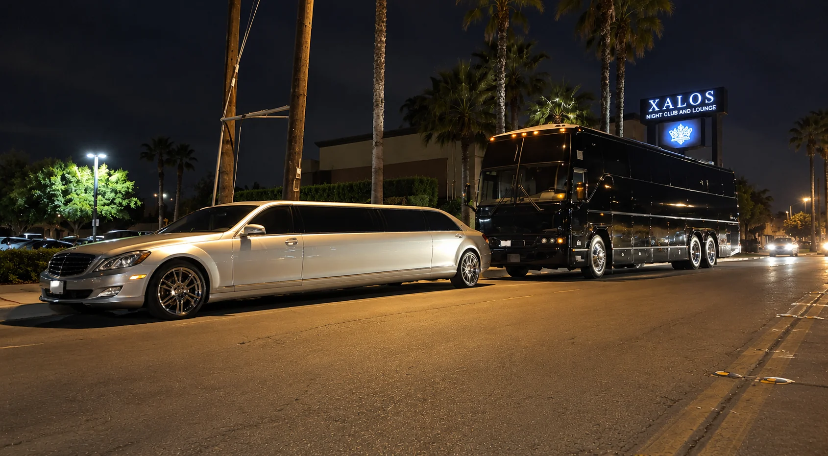 Silver Mercedes stretch limousine and black luxury coach party bus outside a Southern California nightclub at night